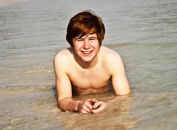 Menino feliz com cabelo vermelho está desfrutando da bela praia — Fotografia de Stock
