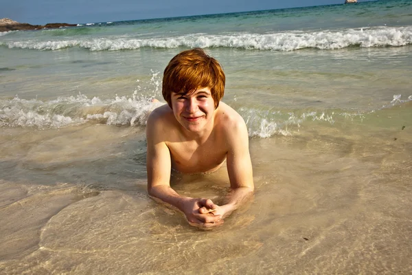 Šťastný chlapec s červenými vlasy se těší na krásnou pláž — Stock fotografie