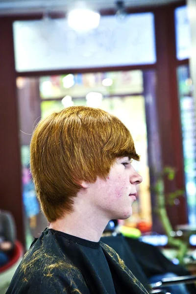 Усміхнений молодий хлопчик у перукарні — стокове фото