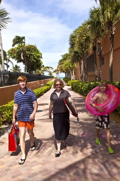 Mamma med söner på väg till stranden med strandutrustning — Stockfoto