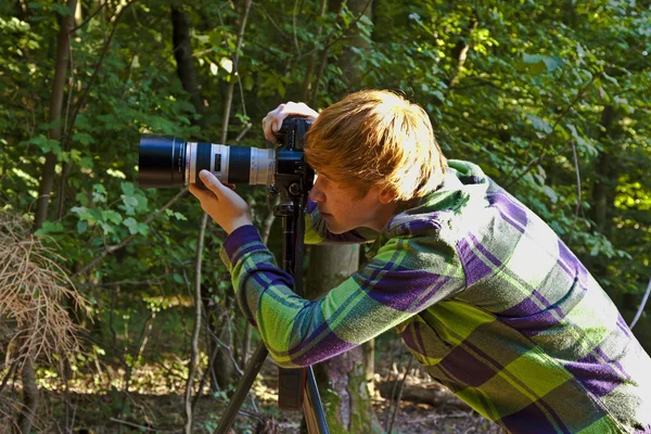 Boy taking pictures with tripot of leaves in detail — Stock Photo, Image