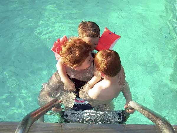 Mamma med sina små barn i poolen — Stockfoto