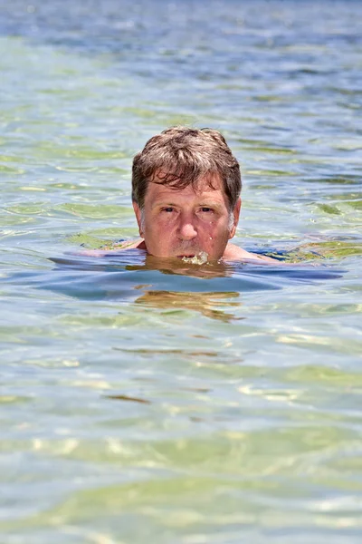 Porträt eines Mannes, der im kristallklaren Ozean schwimmt — Stockfoto