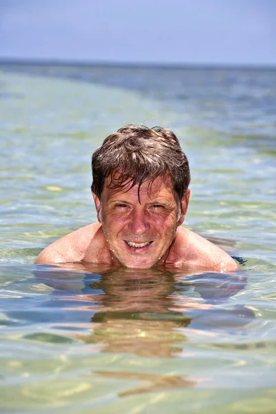 Porträt eines Mannes, der im kristallklaren Ozean schwimmt — Stockfoto
