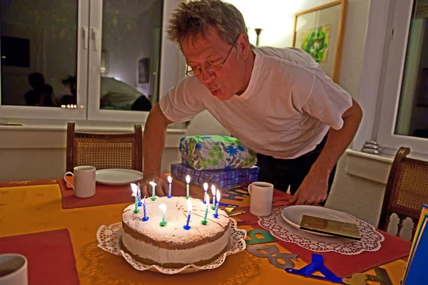 男が彼の誕生日ケーキを吹く — ストック写真