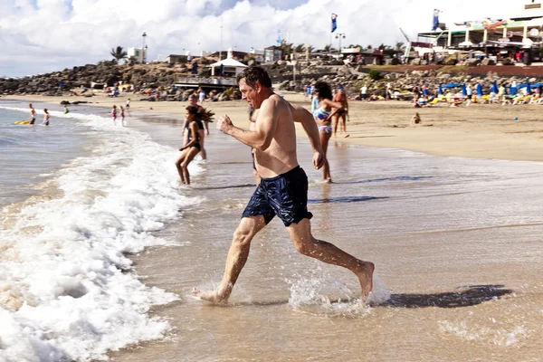 Чоловік біжить на пляжі — стокове фото