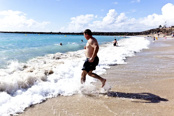 Człowiek działa na plaży — Zdjęcie stockowe