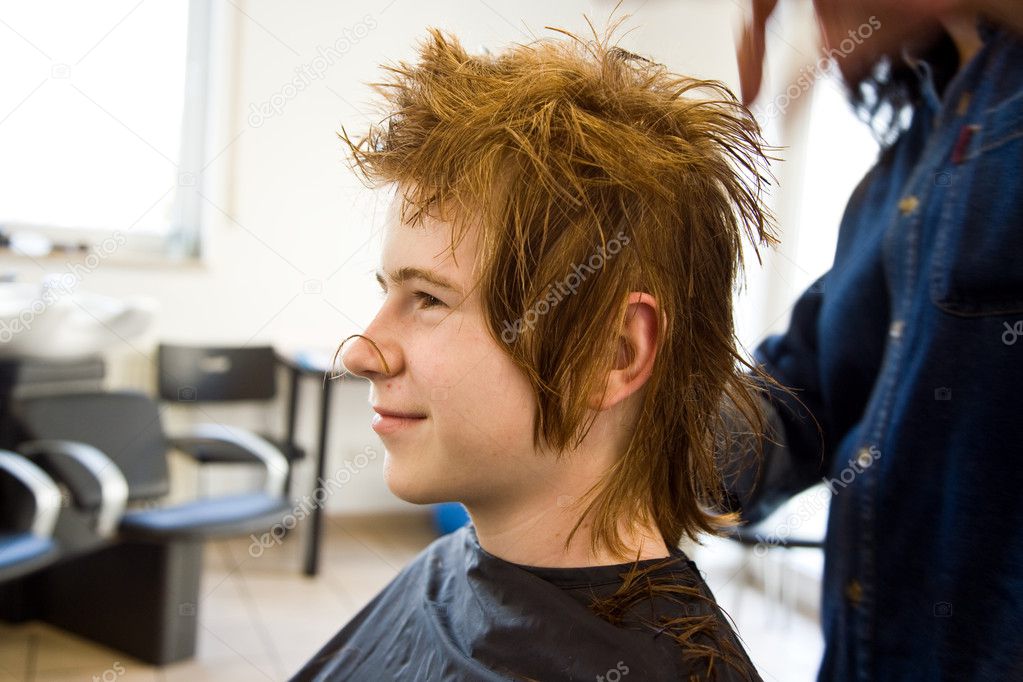 Smiling young boy with red hair at the hairdresser
