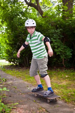 Young boy on his skate board clipart