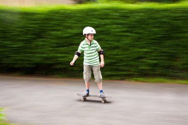 Young boy on his skate board clipart