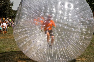 Child has a lot of fun in the Zorbing Ball clipart