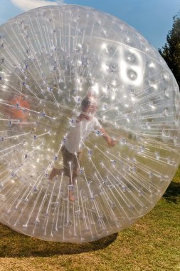 Cute child has a lot of fun in the Zorbing Ball clipart