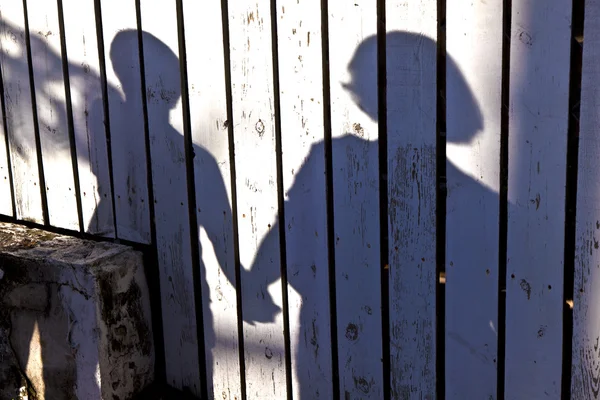 Shadow of a boy with mother at a wooden fence — Stock Photo, Image