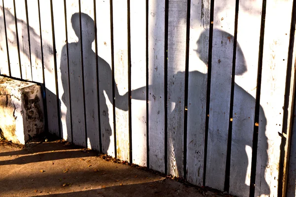 Ombra di un ragazzo con madre in un recinto di legno — Foto Stock