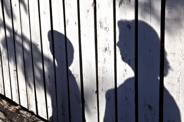 Sombra de um menino com a mãe em uma cerca de madeira — Fotografia de Stock