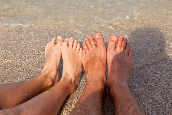 Fötter av far och son på stranden — Stockfoto