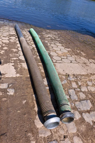 stock image Flexible tubes for disposing liquid manure in the river