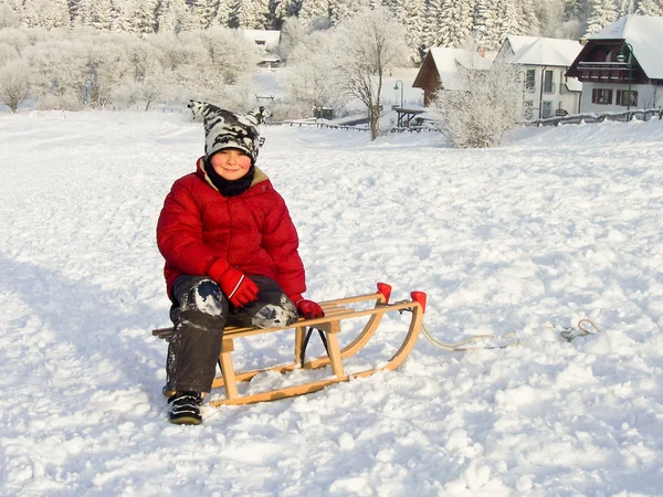 男孩坐在他的雪橇上 — 图库照片