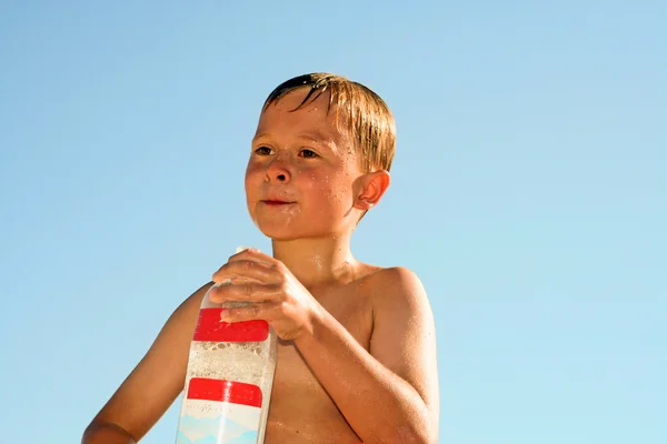Menino feliz thursty bebe água na praia — Fotografia de Stock
