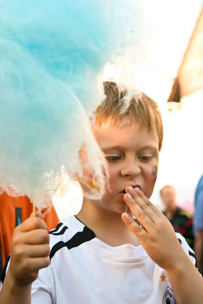 Child is eating cotton candy with fun — Stock Photo, Image
