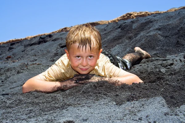 Menino se diverte pulando nas dunas da praia no oceano — Fotografia de Stock