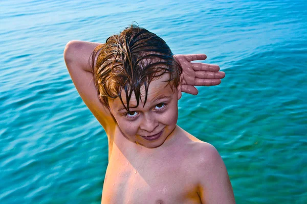 Junge posiert mit Handzeichen im Meer — Stockfoto