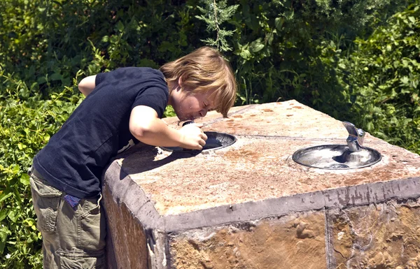 Мальчик пьет воду. — стоковое фото