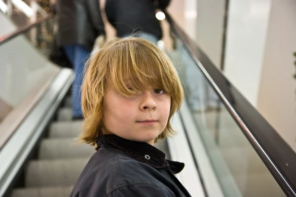 Kind lacht zelf vertrouwen op een trap in een winkelcentrum — Stockfoto
