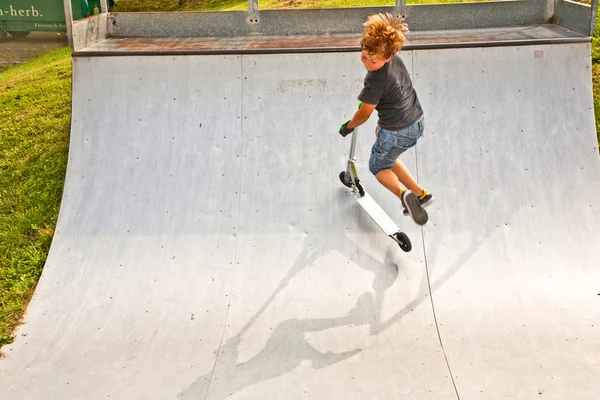Menino está pulando com scooter em tubo — Fotografia de Stock