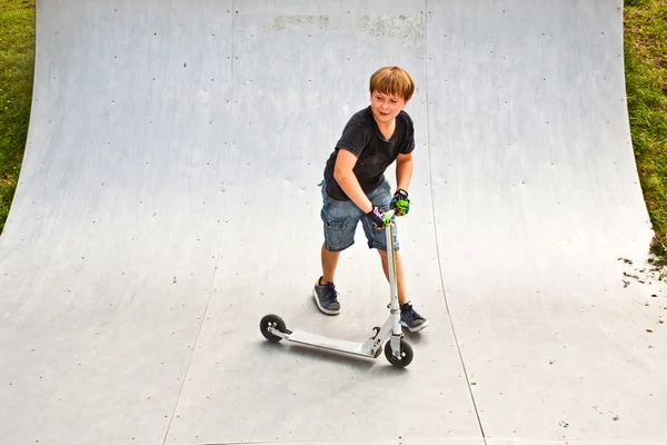 Chico está saltando con scooter en tubería —  Fotos de Stock