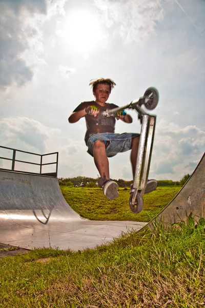 Menino está pulando com scooter em tubo — Fotografia de Stock