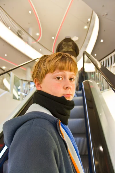 Dziecko na ruchomych schodów wygląda pewność siebie i uśmiech — Zdjęcie stockowe