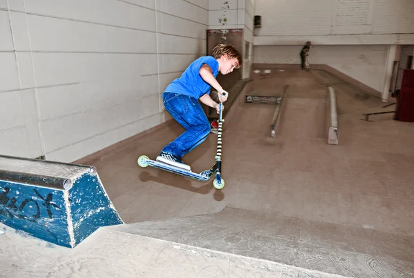 スクーターを持った少年がスケートホールに飛び立ち — ストック写真