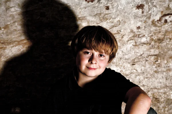 Мальчик в подвале с прожектором — стоковое фото