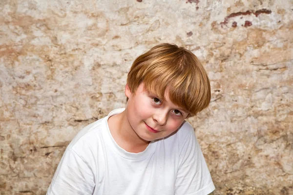 Мальчик со светлыми каштановыми волосами и карими глазами выглядит дружелюбно — стоковое фото