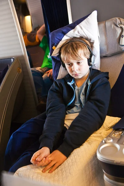 Child is relaxing and watching a film in an aircraft in business — Stock Photo, Image