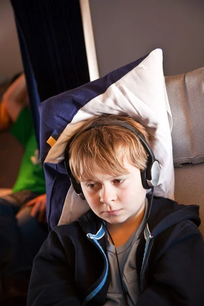 Child is relaxing and watching a film in an aircraft in business — Stock Photo, Image