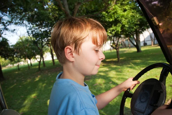 Boy likes to drive an electric car in an old palace of a former — Stock Photo, Image