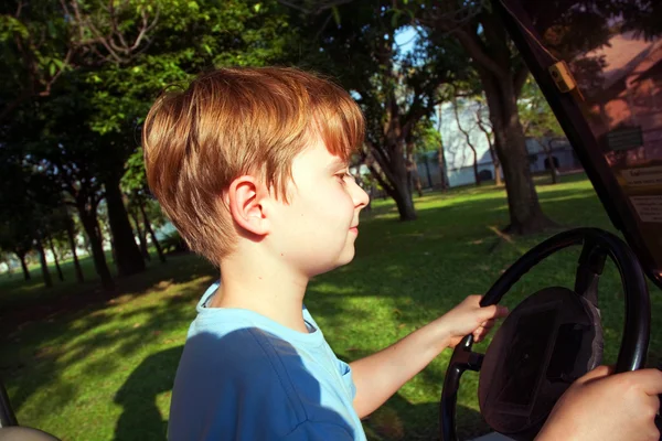 Çocuk eski bir eski bir sarayda bir elektrikli araba sürmeyi seviyor. — Stok fotoğraf