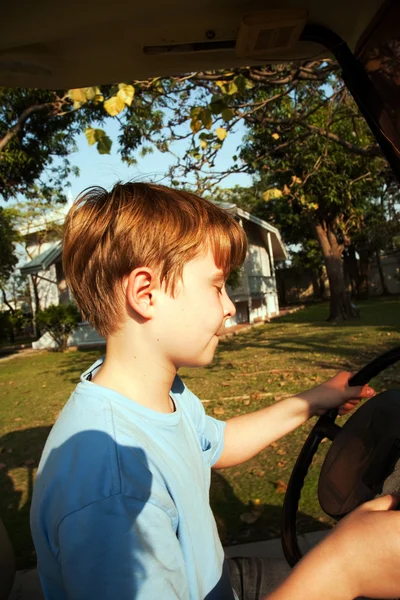 Мальчик любит водить электромобиль в старом дворце бывшего — стоковое фото
