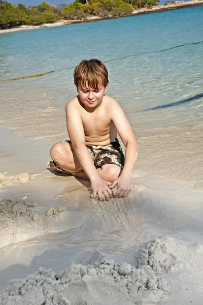 Хлопчики грають на пляжі з піском і будівельними фігурами — стокове фото