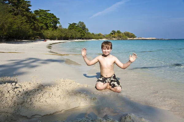 Jungen spielen am Strand mit Sand und bauen Figuren — Stockfoto
