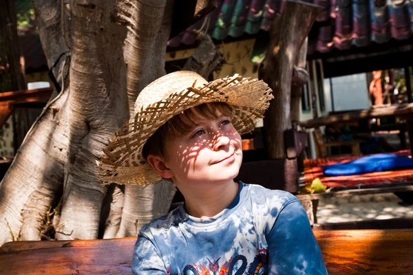 Pojken är avkopplande, leende och glad och har en vila i solen på — Stockfoto