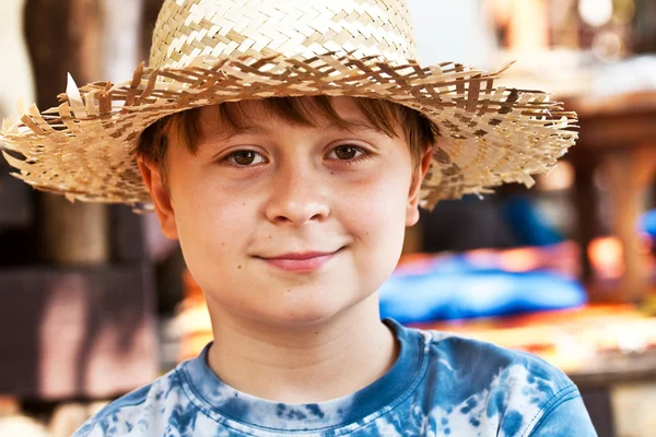 Niño con sombrero de paja es feliz y sonríe —  Fotos de Stock