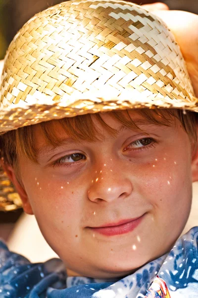 Мальчик в соломенной шляпе счастлив и улыбается. — стоковое фото