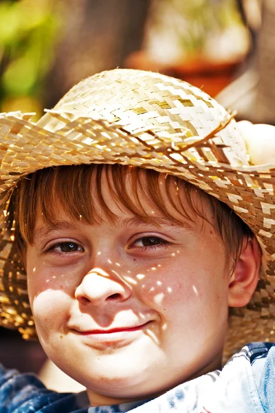 Ung pojke med stråhatt är glad och ler — Stockfoto