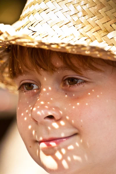 Młody chłopiec Słomkowy kapelusz jest szczęśliwy i uśmiecha się — Zdjęcie stockowe