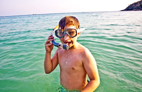 Fiatal fiú áll a gyönyörű kristálytiszta tenger, élvezve a w — Stock Fotó