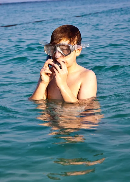 Young boy is standing in the beautiful clear sea, enjoying the w — Stock Photo, Image