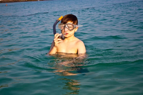 Kleiner Junge steht im schönen klaren Meer und genießt die Sonne — Stockfoto